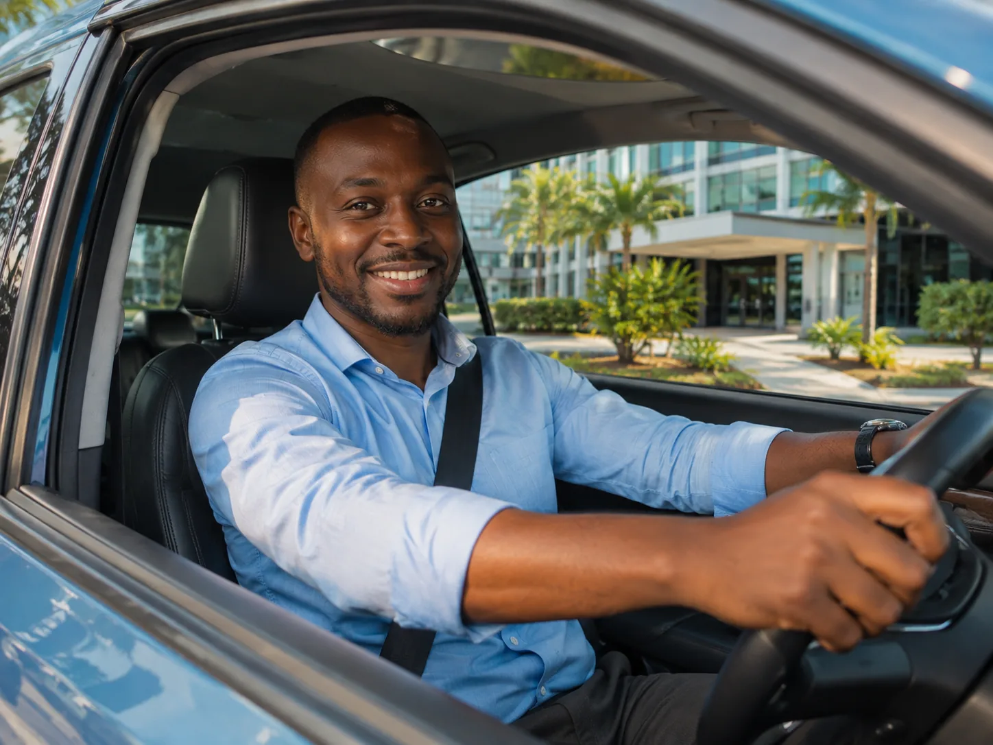 Conducteur souriant au volant de sa voiture